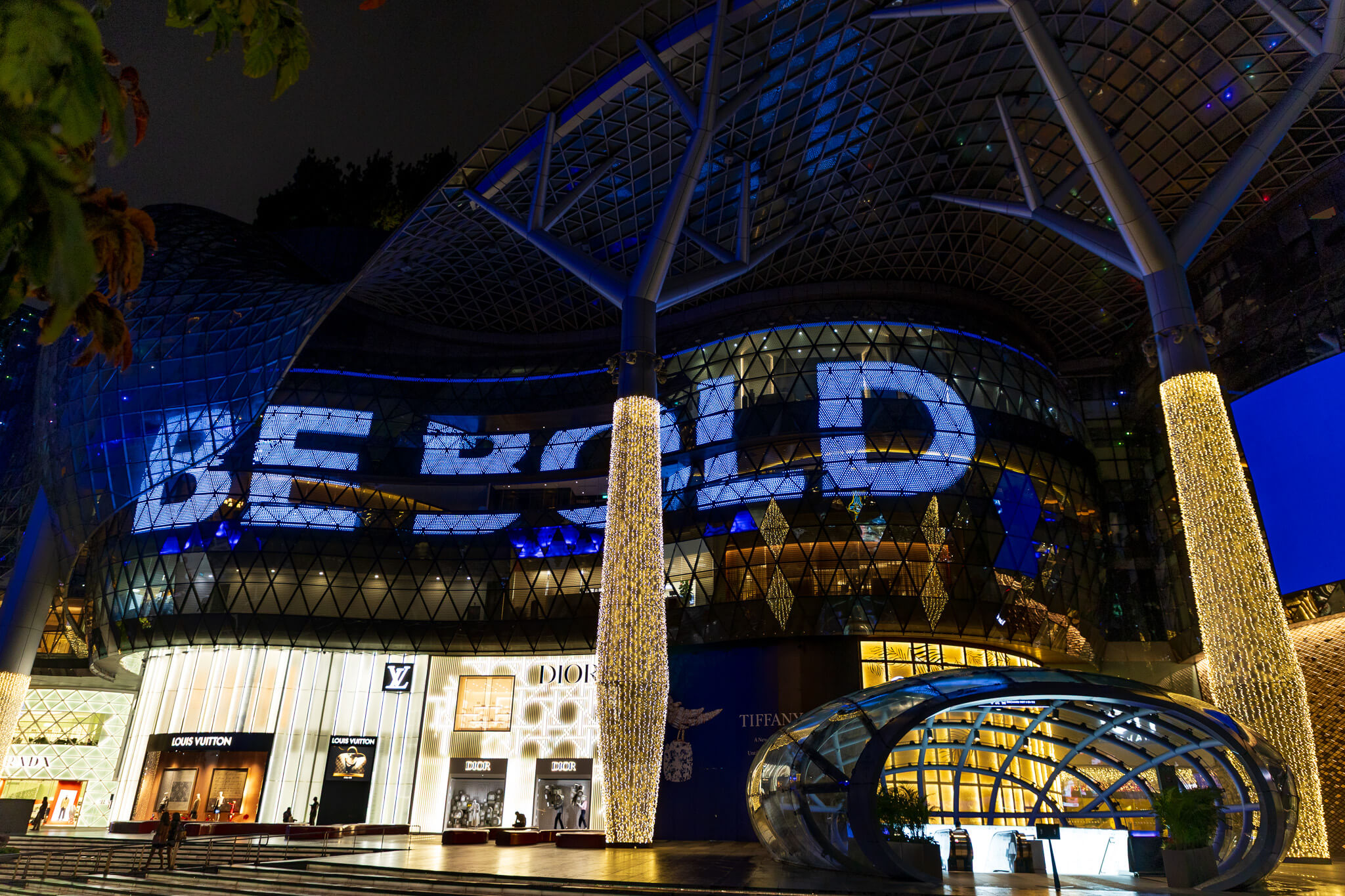 ION Orchard mall at night with BE BOLD projected on facade and luxury brands below, Singapore